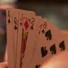 A close-up view of a hand holding several playing cards. Produktbild-Vorschau