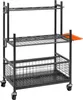 A black metal garden tool organizer cart with three shelves and two baskets. An orange rake is attached to the side. Náhled obrázku produktu