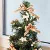 A close-up view of a small, decorated artificial Christmas tree with gold bows, rose gold ornaments, and a white reindeer. Produktbild-Vorschau