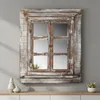 A decorative mirror designed to look like a window with shutters, placed on a shelf. Produktbild-Vorschau