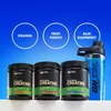 Three tubs of creatine powder and a shaker bottle are displayed against a blue gradient background. Three circles with flavor names are above the tubs. Produktbild-Vorschau