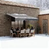 People sitting at a table under an awning on a snowy day. Náhľad obrázku produktu
