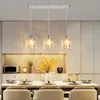 A dining table set with place settings and a chandelier hanging above. Produktbild-Vorschau