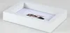 A white shadow box frame with a small illustration of a woman inside, displayed on a white surface. Produktbild-Vorschau