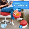 A person is sitting on a red rolling stool and cleaning it. Náhľad obrázku produktu