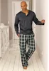 A man wearing pajamas stands in a hallway. Produktbild-Vorschau