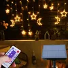 A hand holding a remote control in front of a string of star and moon-shaped LED lights. Náhľad obrázku produktu