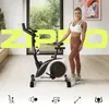 A woman stands next to a stationary bike in a bright, modern room. Produktbild-Vorschau