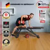 A man is using a weight bench with dumbbells in a home gym setting. Produktbild-Vorschau