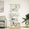 A white bookshelf filled with books and decorative items, placed in a room next to a sofa and a plant. Náhľad obrázku produktu