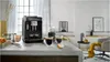A black espresso machine is brewing coffee in a modern kitchen setting. Anteprima dell’immagine prodotto