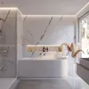Ambiente Bild einer weißen Badewanne mit einseitiger Abrundung in einem hellen, modernen Badezimmer. Produktbild-Vorschau