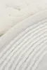 A close-up view of a textured fabric, likely a bath mat, showing its woven pattern and edge. Podgląd zdjęcia produktu