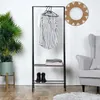 A clothing rack with clothes and shoes, next to a plant and a chair. Náhled obrázku produktu