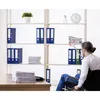 A man in a wheelchair is reaching for files on a shelf in an office setting. Produktbild-Vorschau