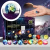 A hand holding small planet-like ornaments in front of a galaxy-themed advent calendar. Náhled obrázku produktu