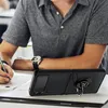 A person is sitting at a desk, writing, with a black phone case on a foldable phone placed in front of them. Produktbild-Vorschau