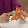A child's hands are shown interacting with an orange dinosaur toy. Produktbild-Vorschau