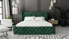 A bedroom with a green upholstered bed, white bedding, and a chair. Náhľad obrázku produktu