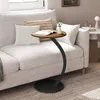 A round side table with a wooden top and black metal base is placed next to a white sofa in a living room setting. Produktbild-Vorschau