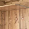 A close-up view of a wooden shelf with three hooks attached to a wooden panel below it. Voir les images du produit