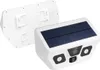 A white solar-powered outdoor camera with a solar panel on top and a mounting bracket in the background. Produktbild-Vorschau