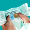 Hands holding a diaper with cartoon characters representing pee and poop inside. Podgląd zdjęcia produktu