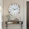 A decorative clock hangs on a wall above a console table with decorative items. Podgląd zdjęcia produktu