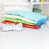 A stack of vacuum-sealed bags filled with clothes and bedding, with a folded shirt in front. Voir les images du produit