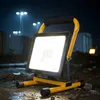 A portable LED work light is set up on a construction site at night, illuminating the muddy ground and surrounding structures. Anteprima dell’immagine prodotto