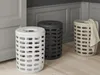 Three laundry baskets of different colors are placed on a wooden floor in a room with gray walls and doors. Produktbild-Vorschau
