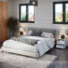 A bedroom scene with a bed, nightstands, and a wardrobe. Náhľad obrázku produktu