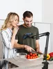 A couple is in a kitchen preparing food, with a phone holder mounted on the counter. Podgląd zdjęcia produktu