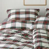 A close-up view of a bed with plaid bedding. Produktbild-Vorschau