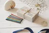 A gift box with pens and nautical decorations on a wooden table. Produktbild-Vorschau
