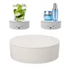 Three images of a white rotating display stand. The top left shows a glass of drink on the stand. The top right shows cosmetic products on the stand. The bottom image shows the stand itself. Náhled obrázku produktu