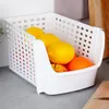 A white plastic storage bin filled with fruits on a countertop. Anteprima dell’immagine prodotto