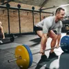 Two people are working out in a gym, lifting weights. Produktbild-Vorschau
