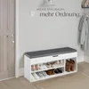 A shoe bench with storage is placed in an entryway next to a door, with shoes organized on its shelves. Produktbild-Vorschau