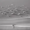 Close-up of water droplets on a grey fabric surface, with a zipper visible in the foreground. Náhled obrázku produktu
