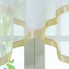 A close-up view of sheer curtains with a decorative ribbon trim. Produktbild-Vorschau