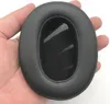A hand holding a black headphone earpad. Produktbild-Vorschau