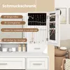 A white jewelry cabinet with its doors open, displaying various compartments for rings, earrings, and necklaces. The cabinet is placed on a white vanity with drawers and decorative items. Text overlays highlight the storage capacity of the cabinet. Voir les images du produit