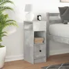 A bedside table with a lamp and alarm clock next to a bed. Voir les images du produit