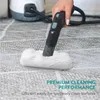 A hand is using a steam cleaner with a microfiber attachment to clean a carpet. Produktbild-Vorschau