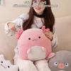 A person sitting on a couch holding a pink axolotl plush toy. Produktbild-Vorschau
