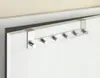 A close-up shot of a silver metal over-the-door hook rack with six hooks, hanging on a white door. Anteprima dell’immagine prodotto