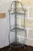 A metal corner shelf unit is shown against a stone and plaster wall. Podgląd zdjęcia produktu