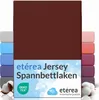 A product image showing a brown fitted sheet with multiple other colored fitted sheets stacked on the sides. Text overlays describe the product and brand. Produktbild-Vorschau