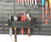 A close-up view of a tool organizer mounted on a pegboard, displaying various tools. Produktbild-Vorschau
